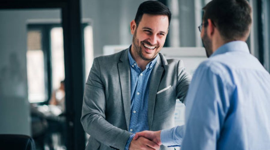 Portrait of cheerful young manager handshake with new employee.